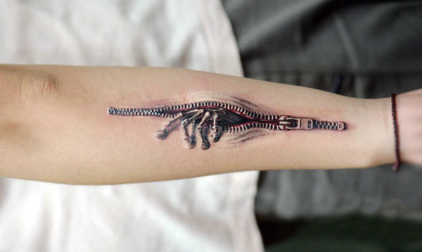 3D tattoo of a zipper on a forearm, creating a mind-twisting illusion.