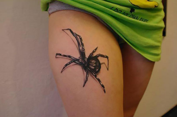 3D tattoo of a spider on a person's thigh creating an optical illusion with a realistic, lifelike appearance.