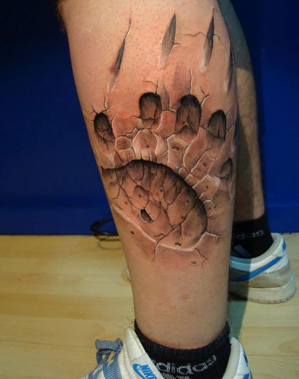 3D tattoo of a bear paw on a leg, creating a realistic and mind-twisting visual effect.