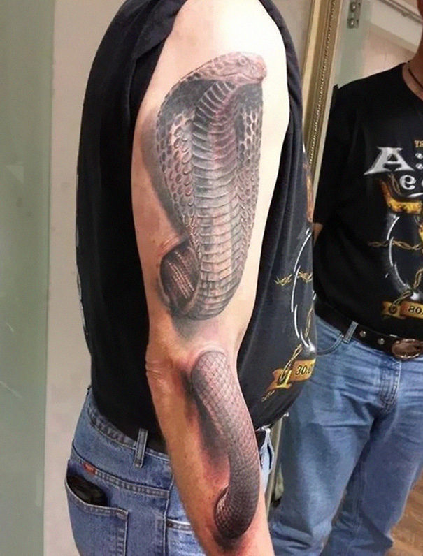 3D tattoo of a cobra on a person's arm, showcasing intricate details and shading.