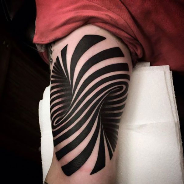 3D tattoo with swirling black stripes creating a mind-bending optical illusion on a person's leg.