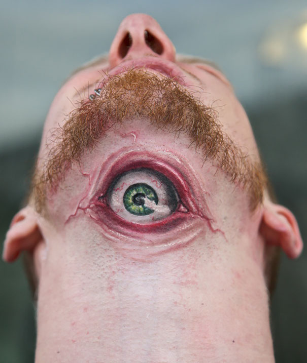 A 3D tattoo of a realistic eye on a man's neck creates a surreal visual effect.