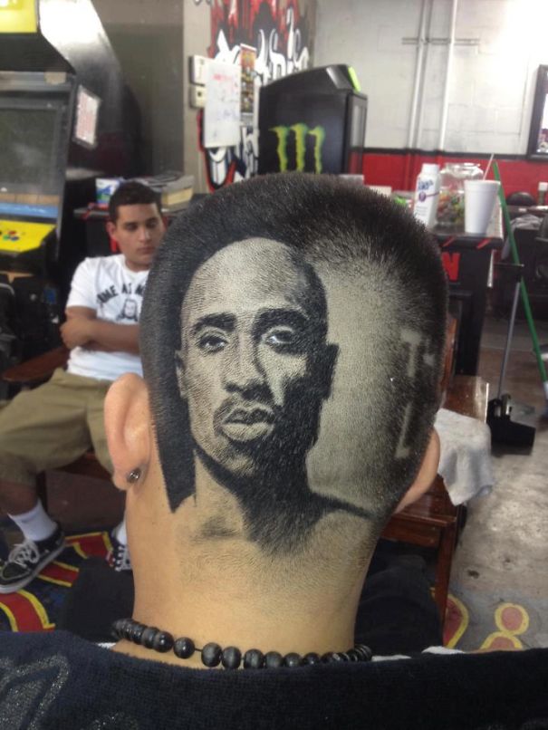 Intricate and artistic haircut featuring a realistic portrait shaved into the back of a person's head.