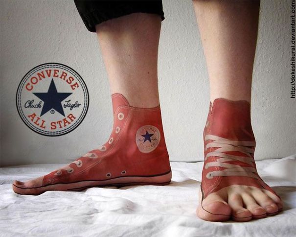 3D tattoo of Converse sneakers on feet; optical illusion design.