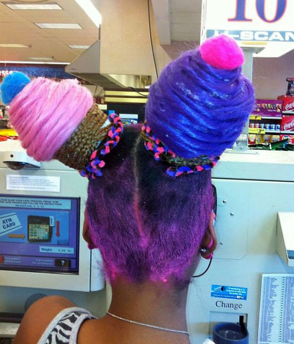 A person with a crazy hairstyle resembling two colorful ice cream cones, featuring pink and purple tones.