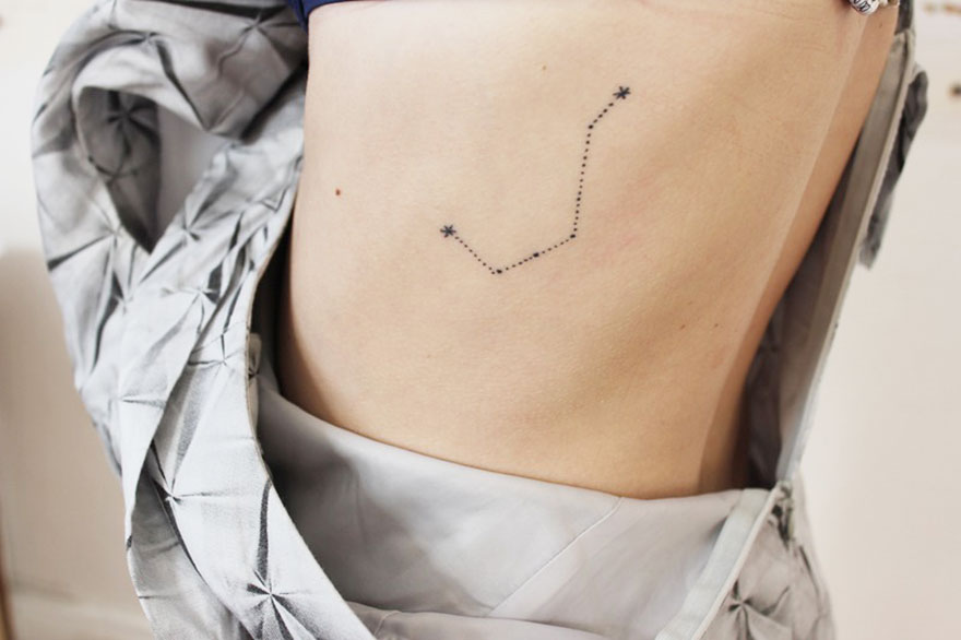 Minimalist tattoo with dots and stars on a person's side, showcasing unique ink art. Minimalist tattoo with dots and stars on a person's side, showcasing unique ink art.