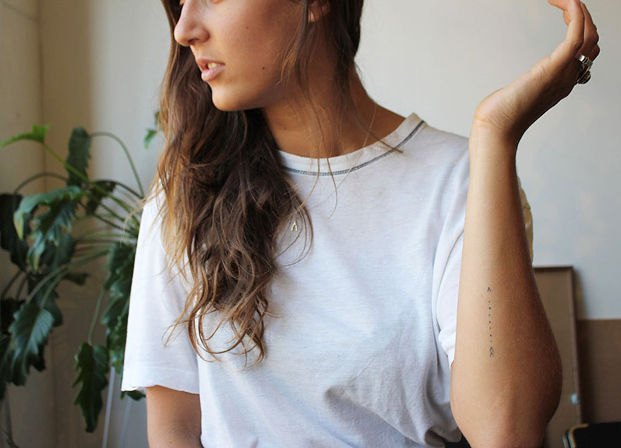 Minimalist tattoo on a woman's arm, featuring simple geometric lines, highlighting artist's unique style. Minimalist tattoo on a woman's arm, featuring simple geometric lines, highlighting artist's unique style.