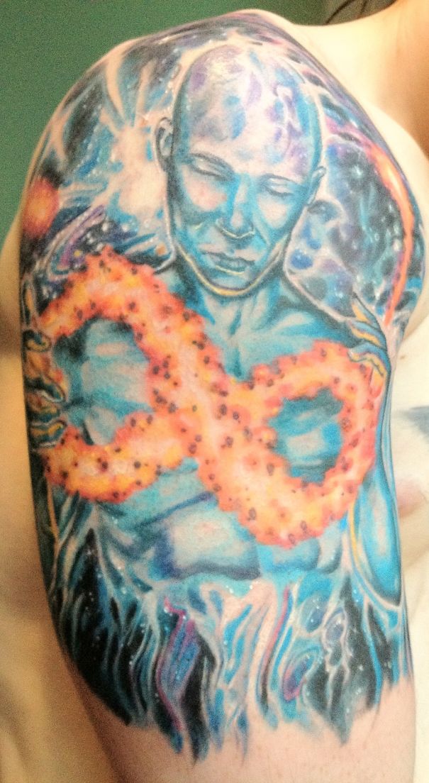 Colorful cosmic tattoo on a man's shoulder, featuring an abstract design with vibrant space elements.