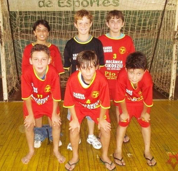 Kids posed in sports jerseys on a court with a hidden detail in the background.