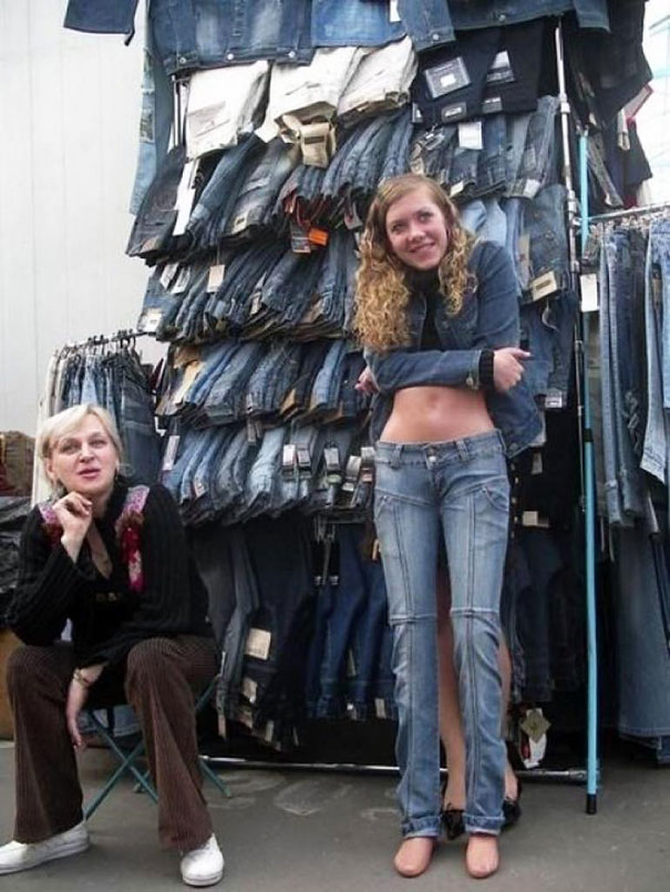 Woman blends into a stack of jeans display, creating an optical illusion.