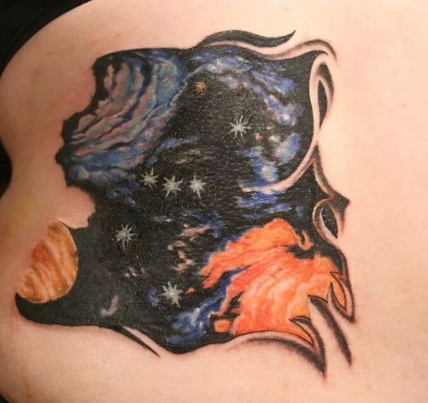 Colorful back tattoo featuring Orion, Jupiter, and nebulae for astronomy lovers.