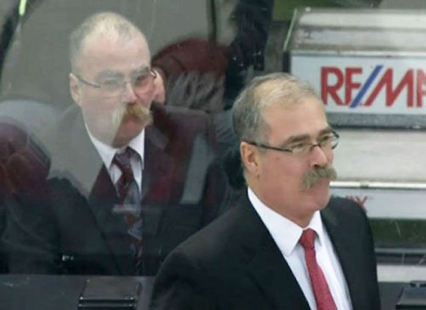 Two man standing wearing suits and looking similar