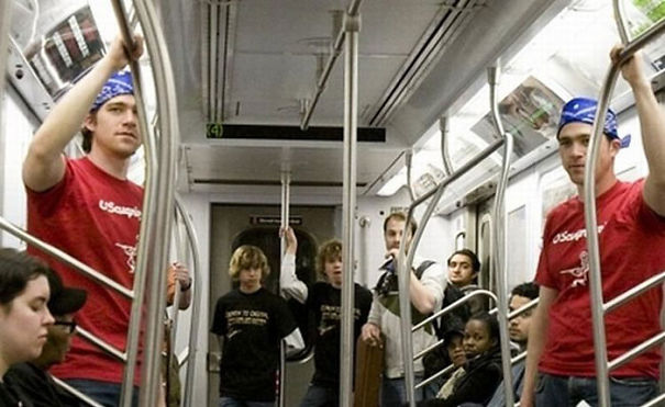 Two man and boys standing in the train and looking similar