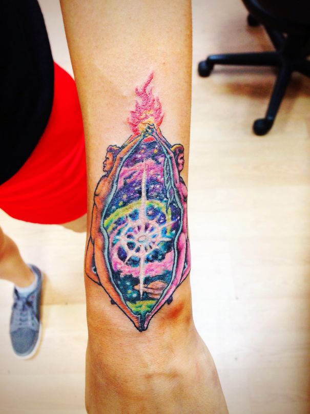 Colorful cosmic tattoo of Twin Flames on an arm, featuring celestial elements for astronomy lovers.