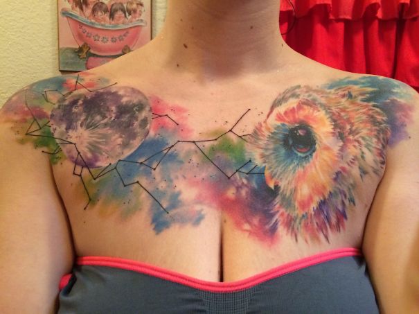 Colorful cosmic owl tattoo on chest, featuring a vibrant astronomy theme.