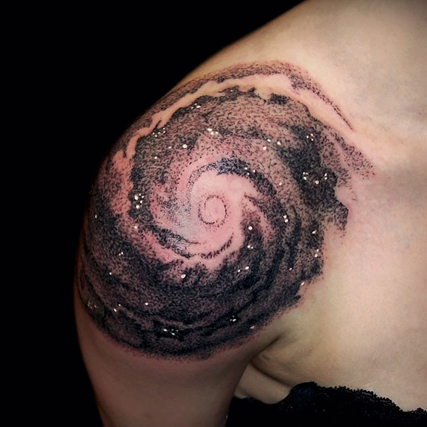 Space-themed shoulder tattoo with a cosmic spiral design for astronomy lovers.