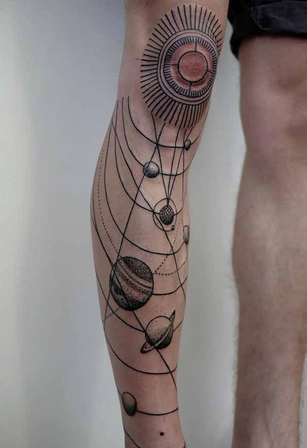 Knee and leg cosmic tattoos featuring planets in an astronomy-themed design.