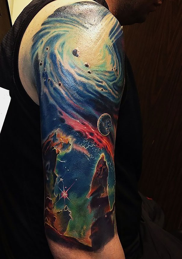 Colorful space-themed arm tattoo featuring cosmic elements, ideal inspiration for astronomy lovers.