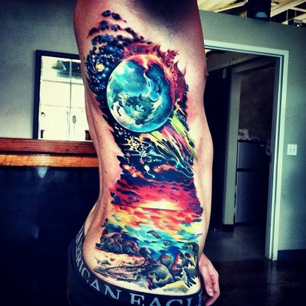 Colorful cosmic tattoo on a person's side, featuring vibrant space and planetary elements.