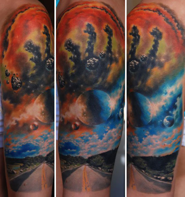 Colorful cosmic tattoo depicting space on an arm, featuring planets and a vibrant nebula.