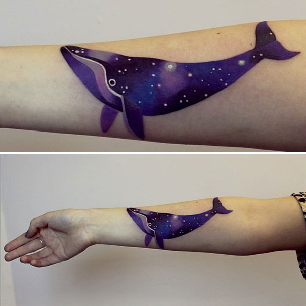Colorful cosmic whale arm tattoo for astronomy lovers.