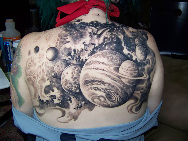 Massive cosmic tattoo featuring planets on a person's back, ideal for astronomy lovers seeking space-themed ink.