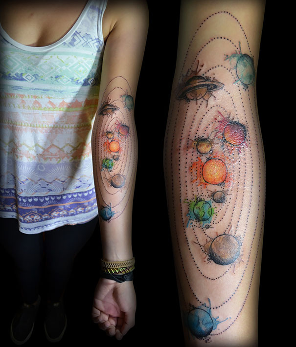 Colorful space and planet tattoo on arm for astronomy lovers.