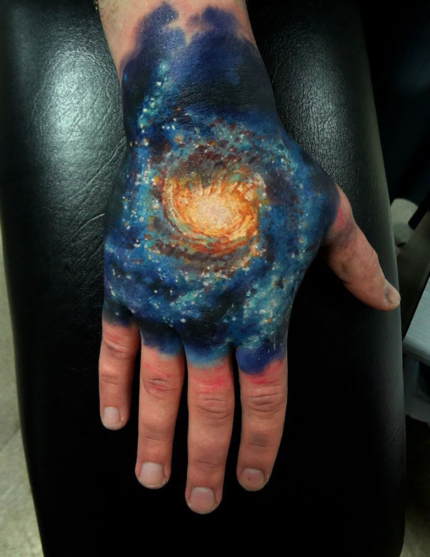 Colorful cosmic tattoo on arm, featuring a galaxy design for astronomy lovers.