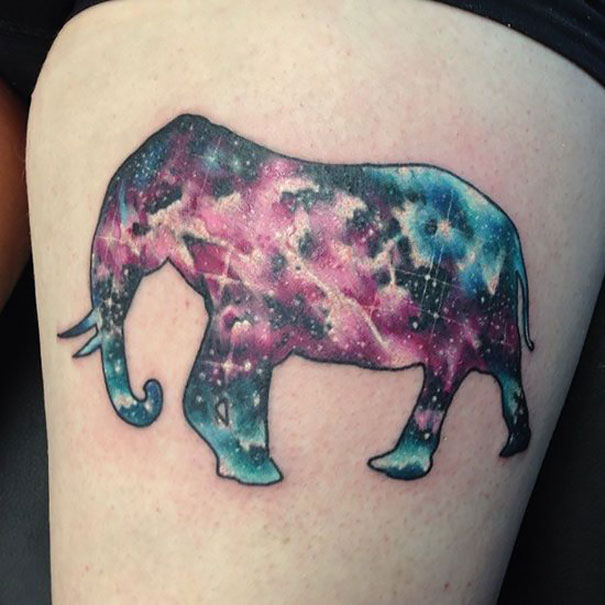 Colorful cosmic elephant tattoo with galaxy theme on leg.