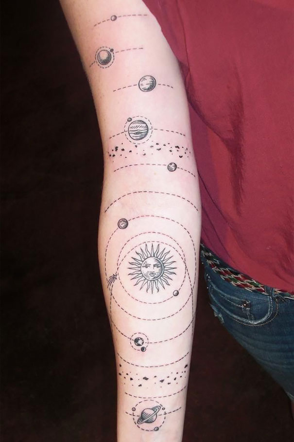 Arm tattoo featuring planets and sun design, perfect for astronomy lovers seeking cosmic inspiration.
