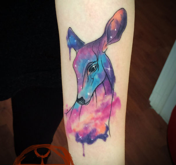 Colorful cosmic Bambi tattoo on arm, blending vibrant nebula hues for astronomy lovers.