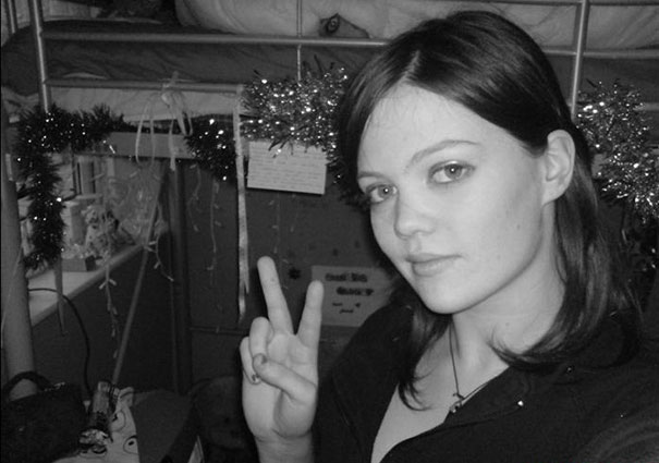 Woman in a decorated room making a peace sign, with a hidden element that surprises viewers.