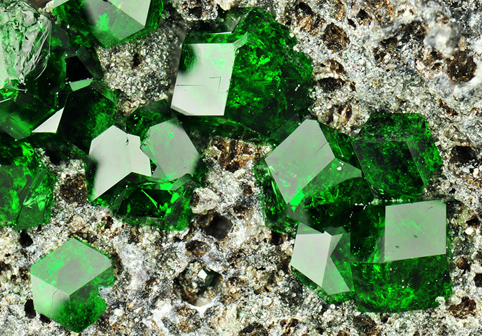 Vivid green mineral crystals on a textured rock surface showcasing beautiful stones.