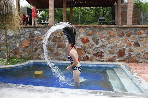 Person creating water arc in a small pool, with a surprising detail hidden in the background.