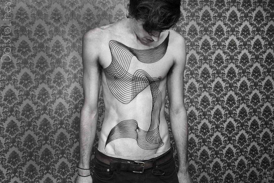 Geometric line tattoo by Chaim Machlev flowing elegantly across a person's torso, set against a patterned background.