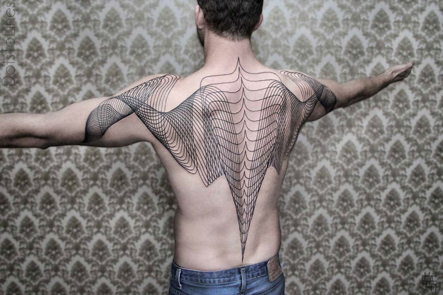 Man with intricate geometric line tattoo by Chaim Machlev flowing elegantly across his back, arms outstretched.