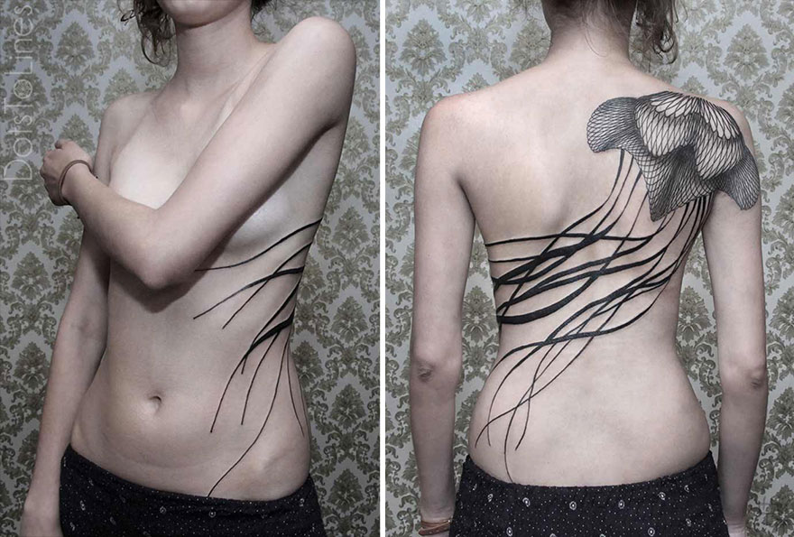 Geometric line tattoo by Chaim Machlev elegantly flows across a woman's side and back in intricate patterns.