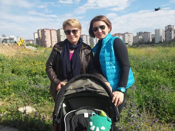 Two women with a stroller in a park; a hidden detail in the sky grabs attention.