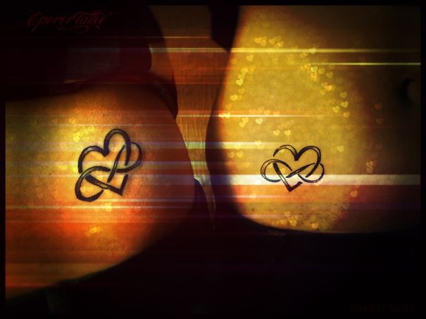 Matching couple tattoos with heart and infinity designs on their skin.