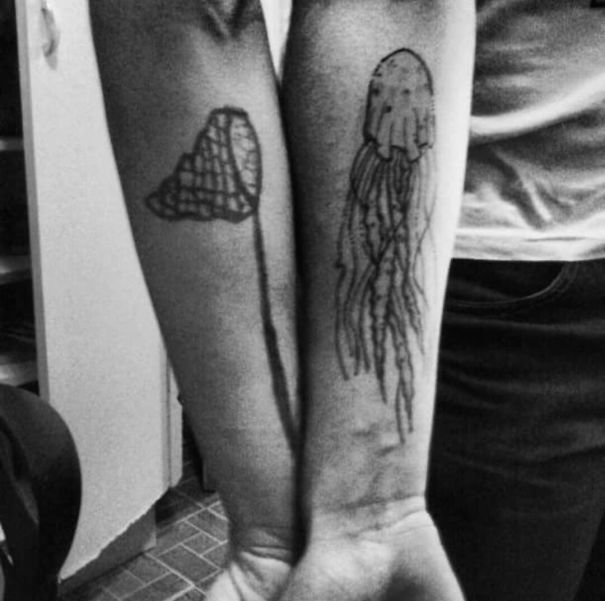 Matching couple tattoos of a jellyfish and flower on forearms, symbolizing long-lasting love.