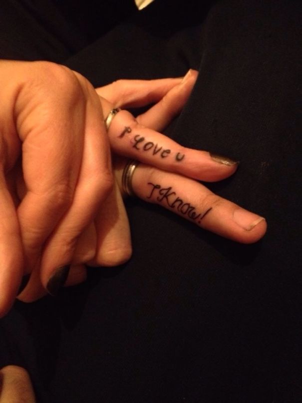 Matching couple tattoos saying "I love u" and "I know" on fingers, symbolizing lasting love.