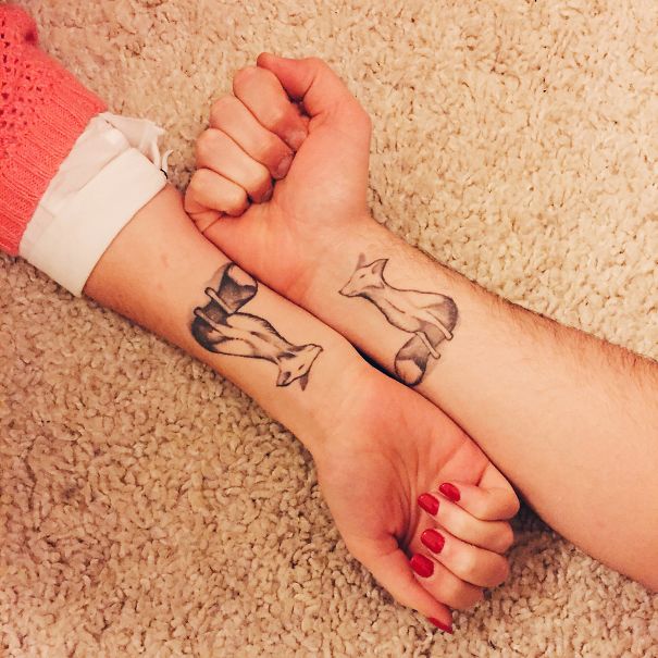 Matching couple tattoos of foxes on wrists, symbolizing love and unity.