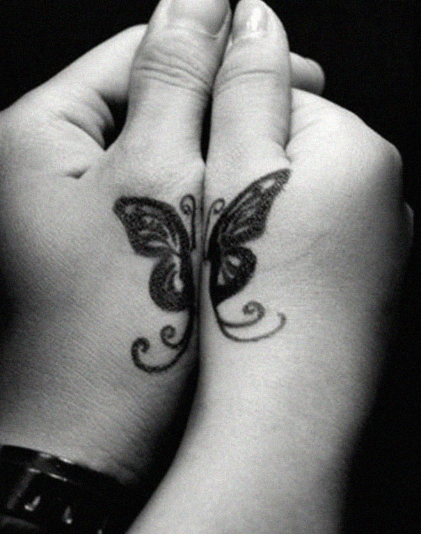 Couple tattoos of a butterfly on hands, symbolizing unity and love.