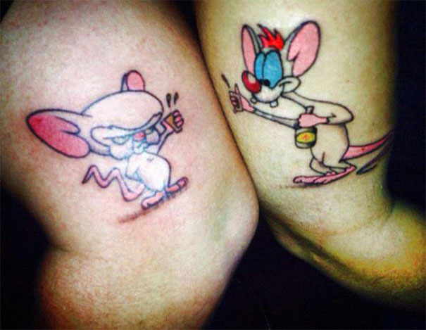 Matching couple tattoos featuring animated mice characters on two arms.