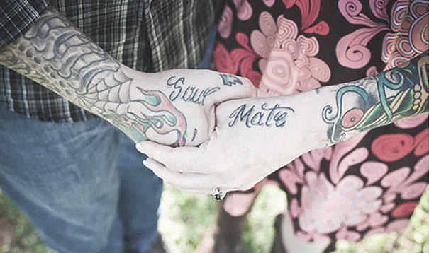 Couple with matching "Soul Mate" tattoos on hands, showcasing their love commitment.