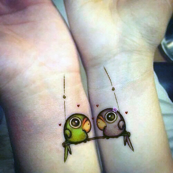 Couple tattoos of birds on wrists, symbolizing love and togetherness.