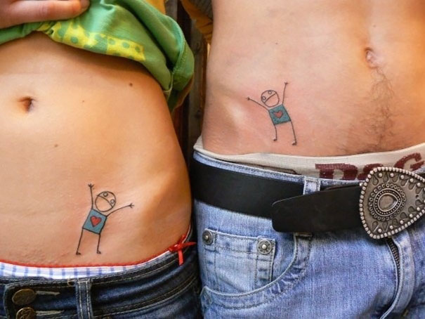 Matching couple tattoos on hips, featuring playful stick figures with hearts, symbolizing love and togetherness.
