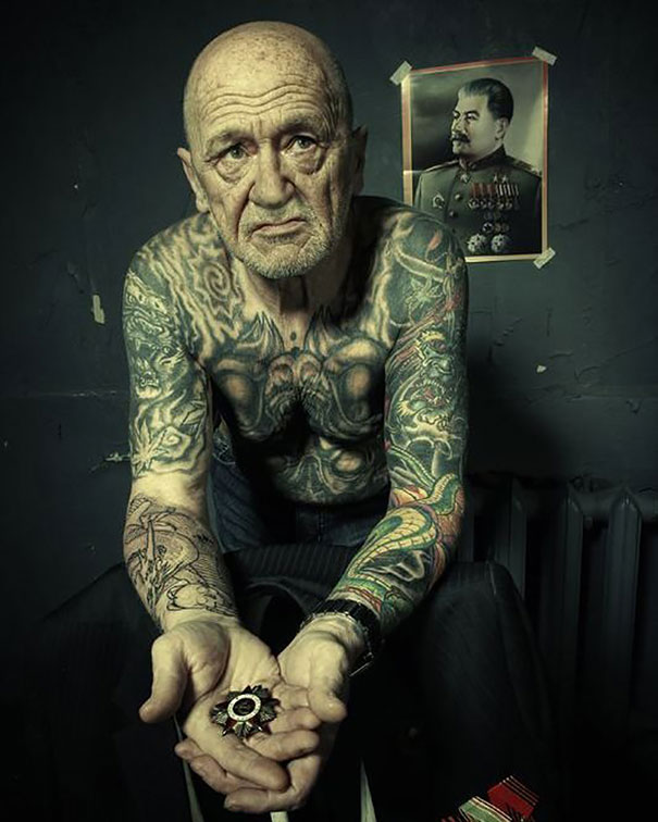 Senior man with tattoos, sitting and displaying inked arms and chest, demonstrating how tattoos look at 60.