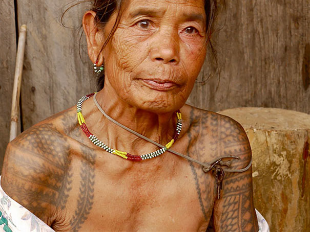 Senior woman with intricate tattoos, showcasing how ink looks at an older age.