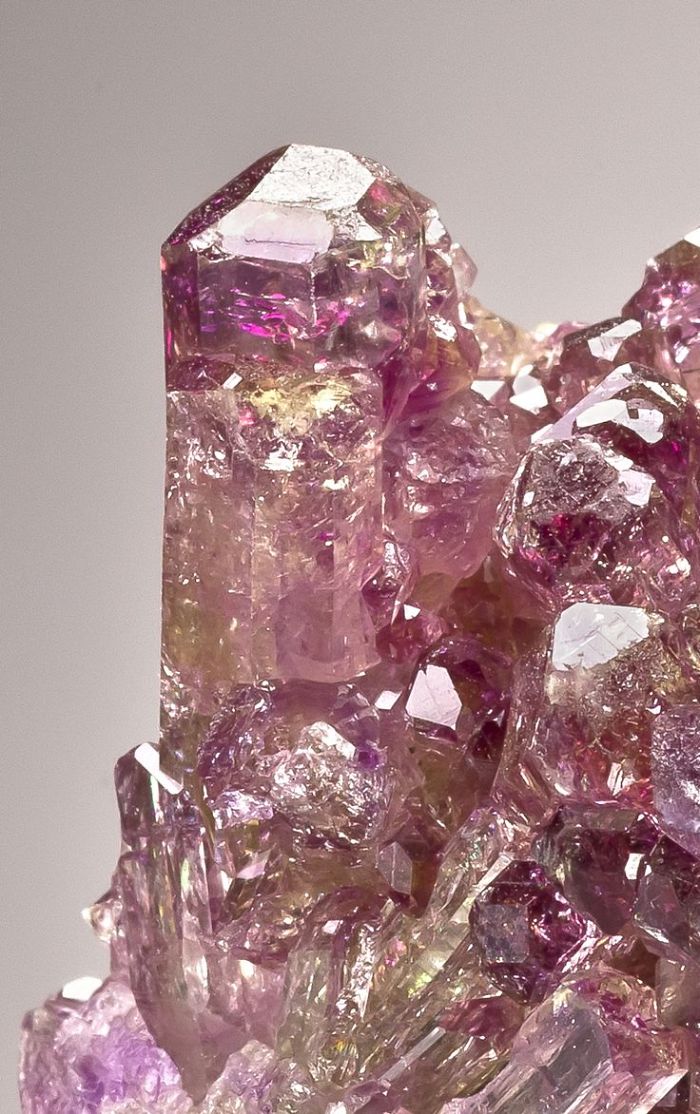Close-up of extremely beautiful purple mineral crystals glistening with light reflections.